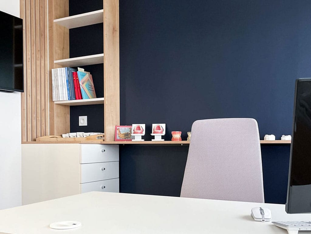 Bureau de consultation du Dr Marin, mur bleu nuit et etageres en bois